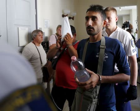 Police escort suspects in the deaths of 71 refugees found in a truck on an Austrian motorway, in Kecskemet, Hungary, August 29, 2015. REUTERS/Laszlo Balogh