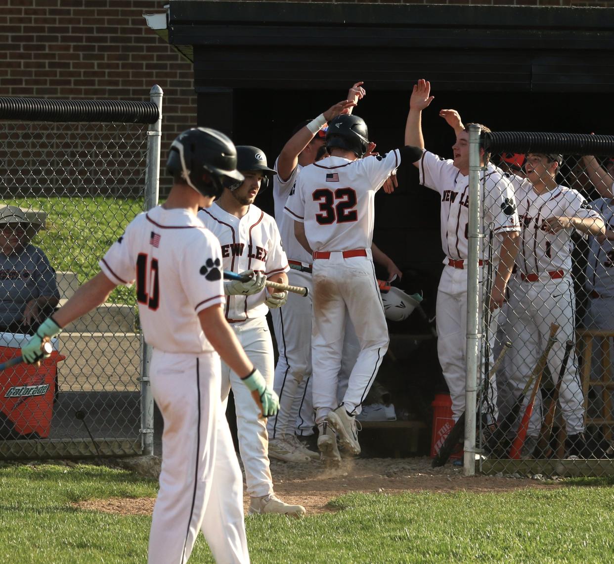 New Lexington's Jonathan Dold is congratulated by teammates after scoring the game-winning run in the sixth inning against Morgan in Tuesday's MVL Small School Division game.