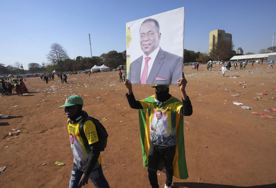 Supporters of Zimbabwe's President Emmerson carry his portrait at a campaign rally in Harare, Aug. 9, 2023. 80-year-old Mnangagwa is now seeking re-election for a second term as president in a vote this week that could see the ruling ZANU-PF party extend a 43-year hold on power. (AP Photo/Tsvangirayi Mukwazhi)
