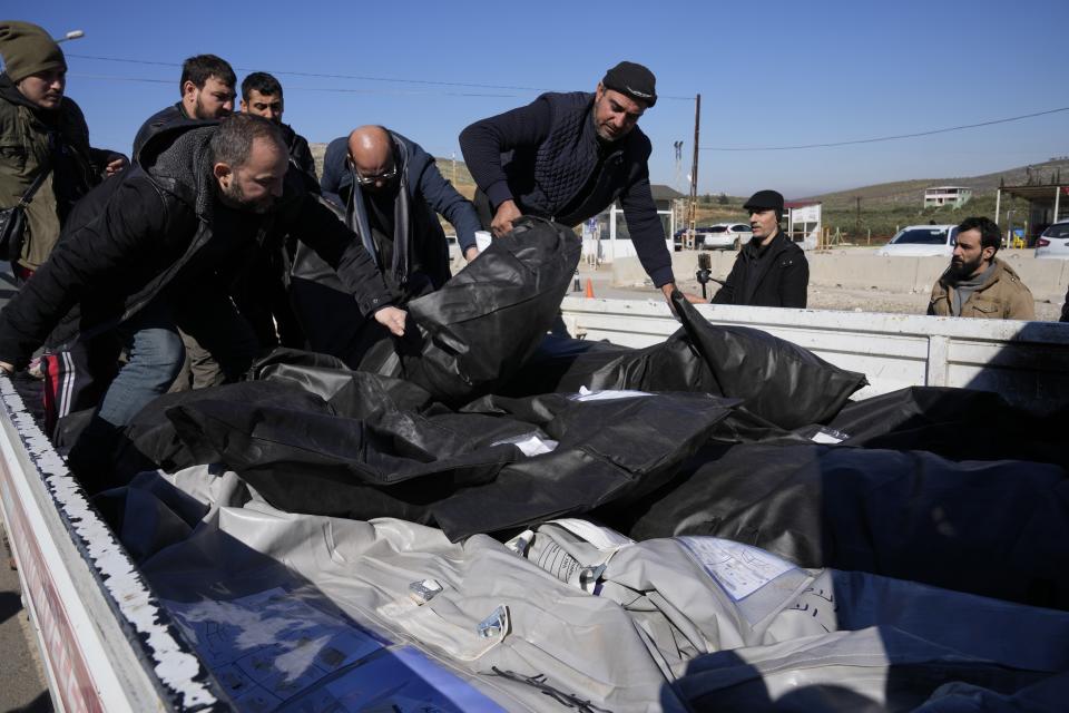 FILE - Men load on a van the bodies of Syrian victims, to transfer to Syria, at the Turkish-Syrian border in Cilvegozu, southeastern Turkey, Thursday, Feb. 9, 2023. For Syrians and Ukrainians fleeing the violence back home, the earthquake that struck in Turkey and Syria is but the latest tragedy. The U.N. says Turkey hosts about 3.6 million Syrians who fled their country’s 12-year civil war, along with close to 320,000 people escaping hardships from other countries. . (AP Photo/Hussein Malla, File)