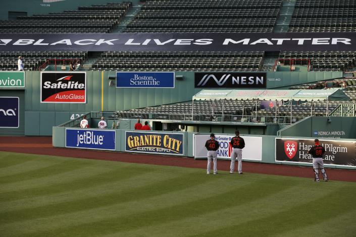 A Black Lives Matter banner is displayed in the bleachers during ceremonies before an opening day baseball game between the Boston Red Sox and the Baltimore Orioles at Fenway Park, Friday, July 24, 2020, in Boston. (AP Photo/Michael Dwyer)