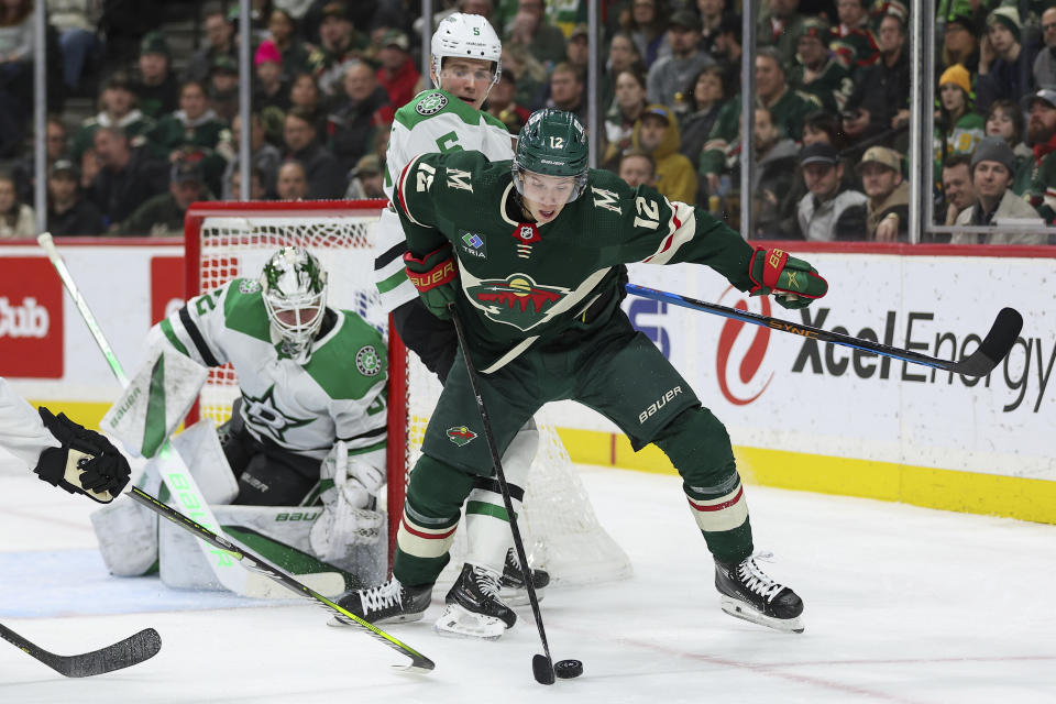 Minnesota Wild left wing Matt Boldy, right, and Dallas Stars defenseman Nils Lundkvist (5) compete for the puck during the second period of an NHL hockey game Monday, Jan. 8, 2024, in St. Paul, Minn. (AP Photo/Matt Krohn)