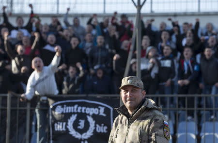 A member of the People's Militia of Crimea stands guard during a soccer match in Simferopol, Crimea, in this March 14, 2015 file photo. REUTERS/Maxim Shemetov/Files