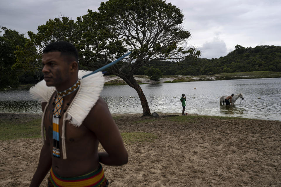 Un miembro de la comunidad indígena participa en una protesta para pedir acciones contra infracciones ambientales en el sistema de dunas de Abaete, en Salvador, Brasil, el domingo 18 de septiembre de 2022.. (AP Foto/Rodrigo Abd)