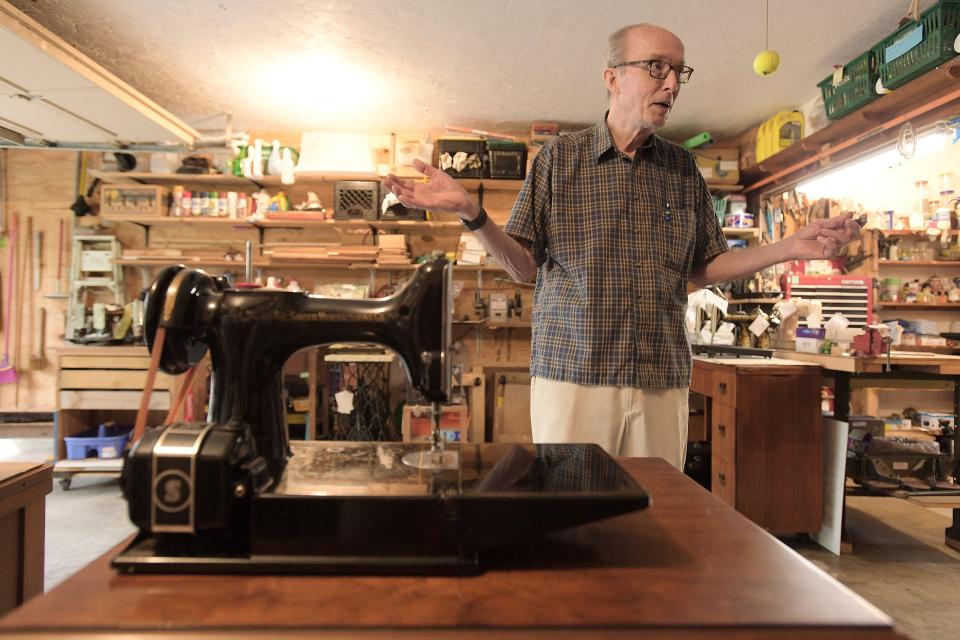 John Niles shows his setup in his garage workshop filled with vintage sewing machines and parts for his restoration projects.