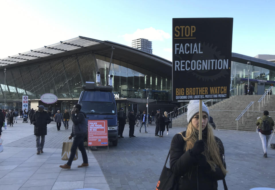 Rights campaigner Silkie Carlo demonstrates in front of a mobile police facial recognition facility outside a shopping centre in London Tuesday Feb. 11, 2020, “We don't accept this. This isn't what you do in a democracy," said Carlo, director of privacy campaign group Big Brother Watch. London police started using facial recognition surveillance cameras mounted on a blue police van on Tuesday to automatically scan for wanted people, as authorities adopt the controversial technology that has raised concerns about increased surveillance and erosion of privacy. (AP Photo/Kelvin Chan)