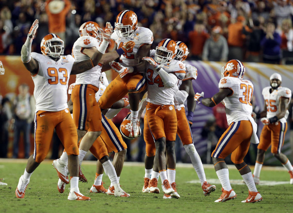 Clemson Tigers linebacker Stephone Anthony (42) celebrates with defensive end Corey Crawford (93) and linebacker Quandon Christian (34) after Anthony intercepted a pass thrown by Ohio State Buckeyes quarterback Braxton Miller during the second half of the Orange Bowl NCAA college football game, Saturday, Jan. 4, 2014, in Miami Gardens, Fla. Clemson defeated Ohio State 40-35. (AP Photo/Lynne Sladky)