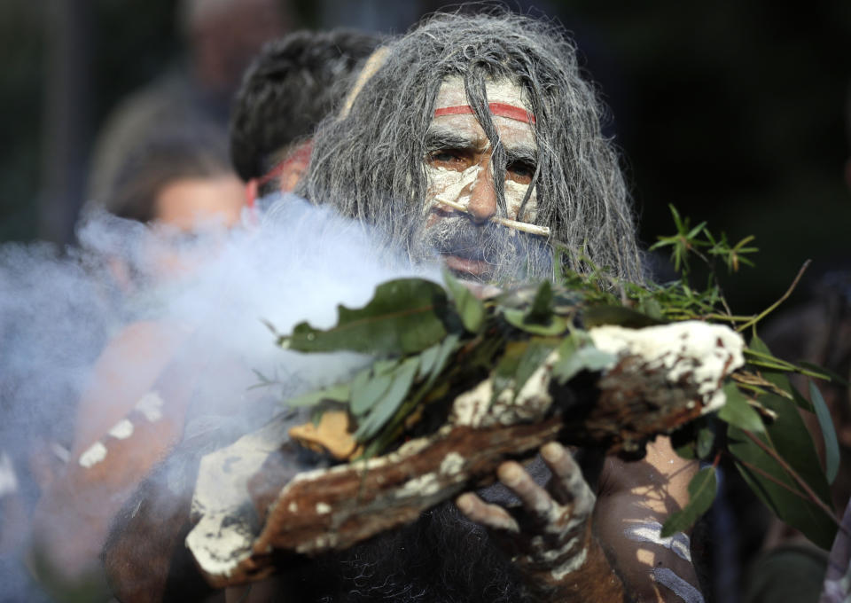 An Aboriginal man performs a smoking ceremony as protesters gather in Sydney, Saturday, June 6, 2020, to support the movement of U.S. protests over the death of George Floyd. Black Lives Matter protests across Australia proceeded mostly peacefully as thousands of demonstrators in state capitals honored the memory of Floyd and protested the deaths of indigenous Australians in custody. (AP Photo/Rick Rycroft)