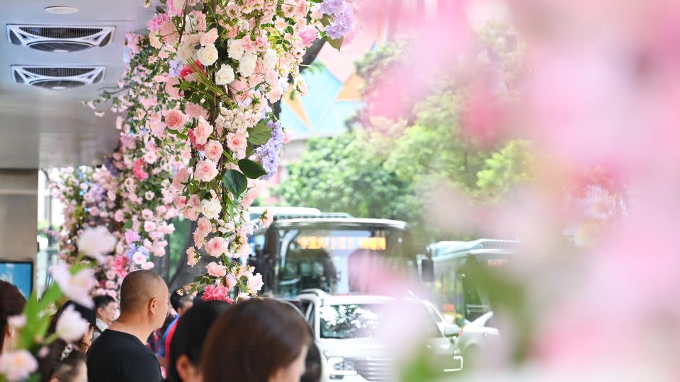 People take photos at a bus stop decorated with flowers during Qixi Festival, or Chinese Valentine's Day, on August 22, 2023 in Chongqing, China. - He Penglei/China News Service/VCG/Getty Images