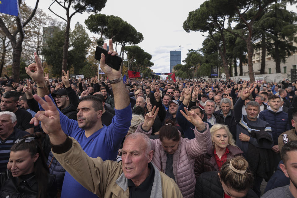 People take part in an an anti-government protest held near a summit of European Union leaders and their counterparts from the Western Balkans in the capital Tirana, Albania, on Tuesday, Dec. 6, 2022. Sali Berisha, a 78-year-old former president, prime minister and the leader of the Albanian opposition center-right Democratic Party has been attacked during protest when a man came out of the crowd and punched him in the face. The opposition was protesting against alleged corruption by Prime Minister Edi Rama, which they blame for the country's cost-of-living crisis.(AP Photo/Franc Zhurda)