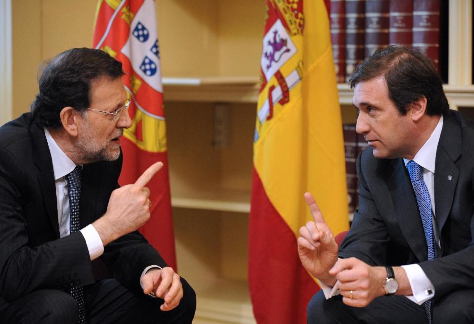 Spain's Prime Minister Mariano Rajoy, left, talks with his Portuguese counterpart Pedro Passos Coelho Wednesday, May 9 2012, upon arriving at the Customs House in Porto, Portugal. The annual summit brings together the two prime ministers of Portugal and Spain. Youth employment and ways to create jobs and to reactivate the economy were some of the main topics for both countries that registered some of the highest unemployment rates of the region. (AP Photo/Paulo Duarte)