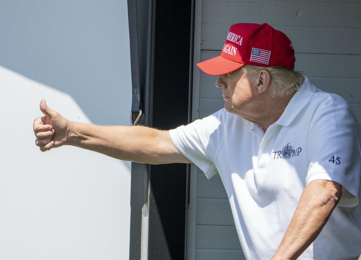 Former U.S. president Donald Trump gives thumbs up as he watches during the first round of the LIV Golf Tournament at Trump National Golf Club in Sterling, Va. (AP Photo/Alex Brandon)