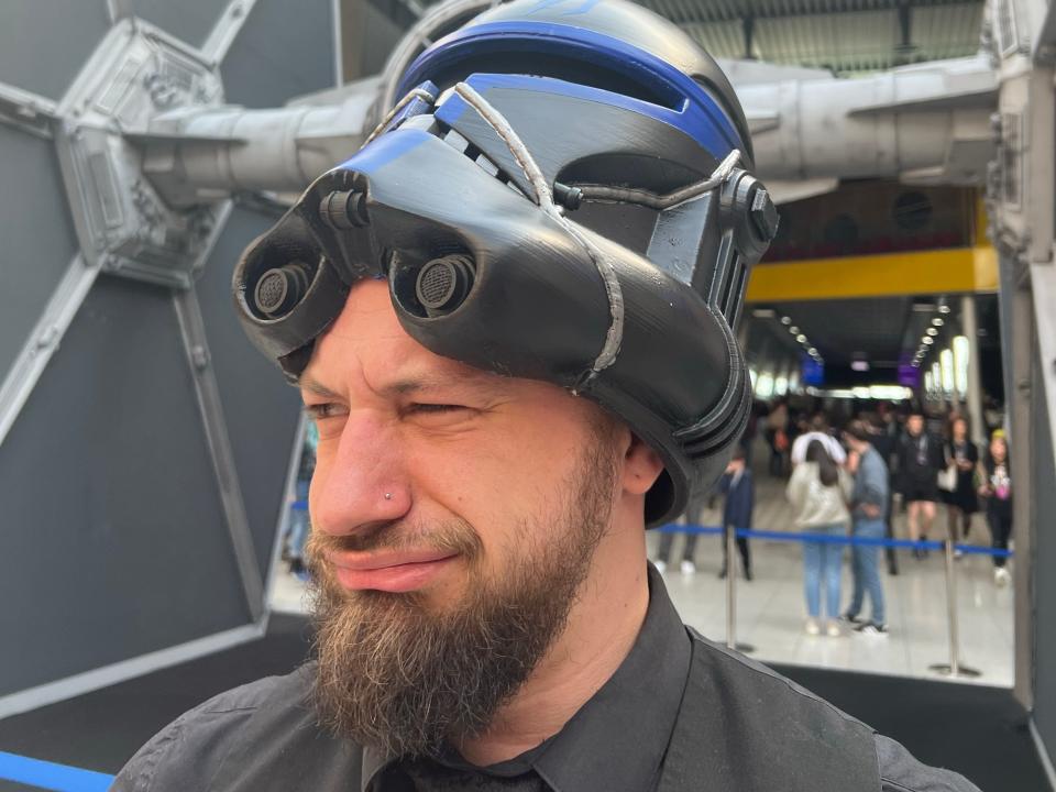 A man with a Clone trooper helmet lifted up on his head.