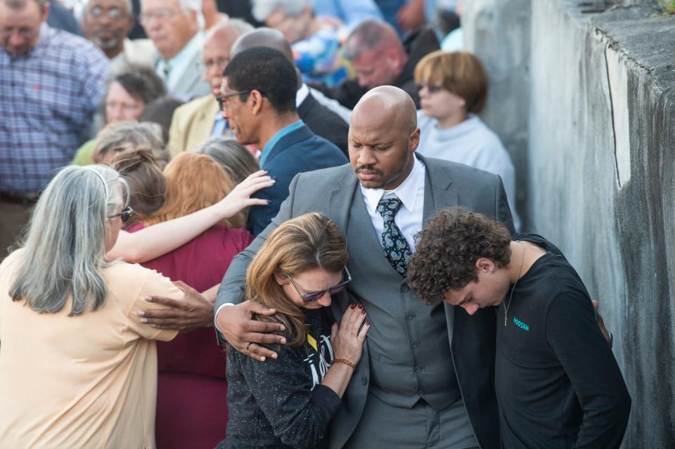 People pray during a vigil Sunday at First Baptist Church in Dadeville.