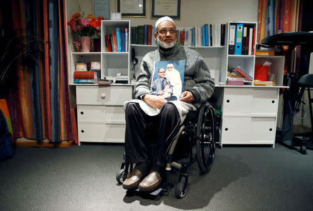 Al Noor mosque shooting survivor Farhid Ahmed poses with a photo of his wife Husna, who was killed in the attack, after an interview with Reuters in Christchurch, New Zealand March 18, 2019. REUTERS/Edgar Su