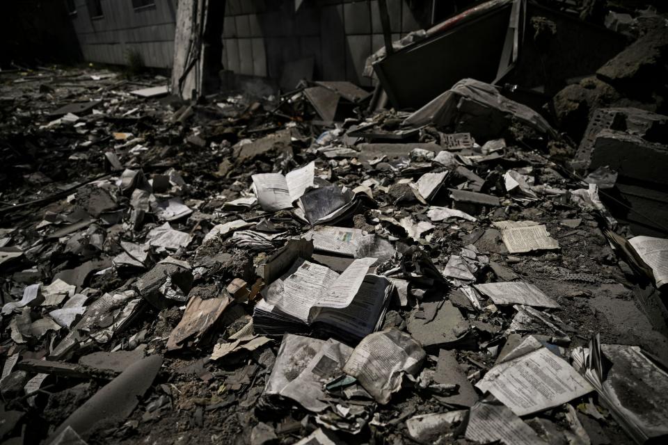 A photograph taken on 8 June shows books scattered outside a school destroyed after a strike in Bakhmut, eastern Ukrainian region of Donbas (AFP via Getty Images)