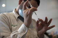 A medical worker prepares a vial of the Pfizer coronavirus vaccine at Clalit Health Service's center in the Cinema City complex in Jerusalem, Wednesday, Sept. 22, 2021. Israel is pressing ahead with its aggressive campaign of offering coronavirus boosters to almost anyone over 12 and says its approach was further vindicated by a U.S. decision to give the shots to older patients or those at higher risk. (AP Photo/Maya Alleruzzo)