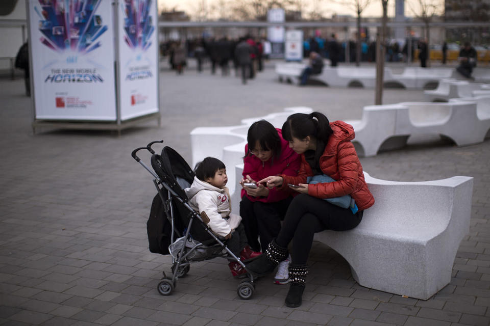 Visitors use their mobile phones during the inauguration of the Mobile World Congress.