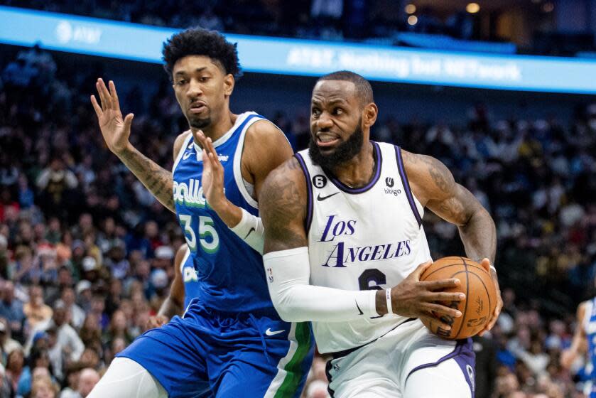 Lakers forward LeBron James (6) drives to the basket against Dallas Mavericks forward Christian Wood on Dec. 25, 2022.