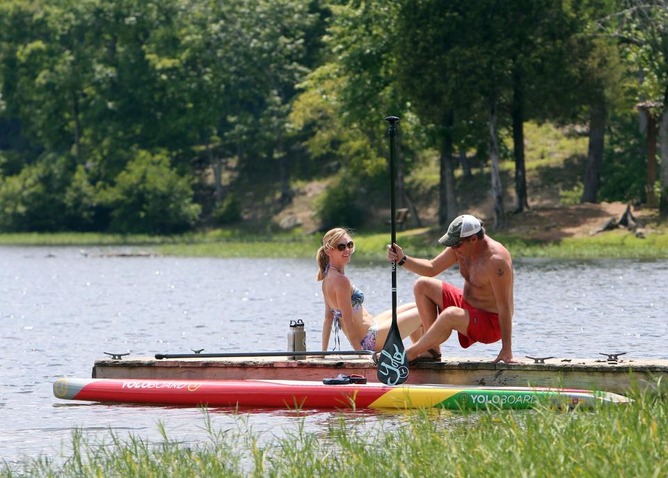 Alyce Smith and her husband Bret, prepare to paddleboard at Lake Nicol in Tuscaloosa, Ala. on Sunday, July 17, 2016. University of Alabama researchers say 'staycations' aren't as satisfying as vacations. [Staff file photo]