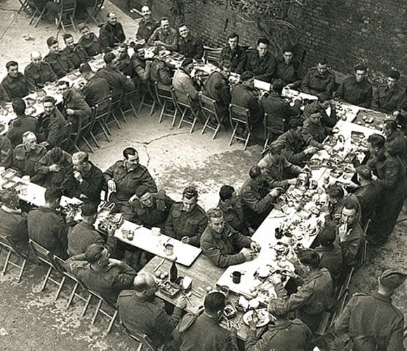 Members of the Seaforth Highlanders of Canada sit down for their Christmas dinner in 1943, in Ortona, Italy, just a few blocks away from front-line fighting. (Library and Archives Canada PA-152839 - image credit)