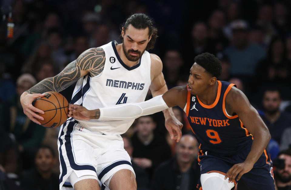 Memphis Grizzlies center Steven Adams, left, holds the ball away from New York Knicks guard RJ Barrett (9) during the first half of an NBA basketball game, Sunday, Nov. 27, 2022, in New York. (AP Photo/John Munson)