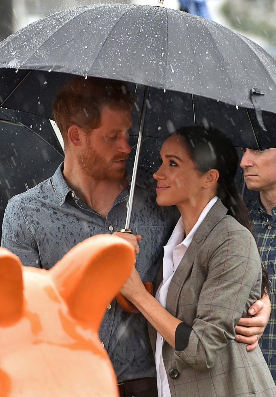 <p>The pair snuggled underneath an umbrella during a downpour in drought-stricken Dubbo, Australia. </p>