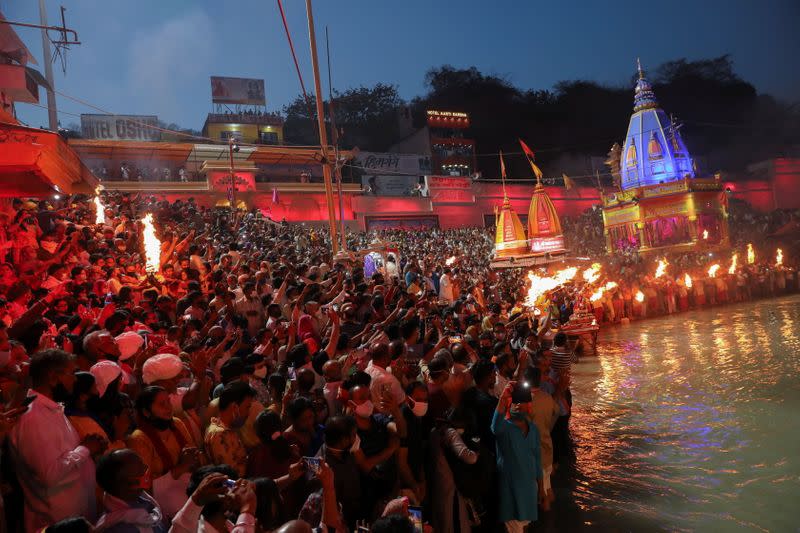 Devotees gather for an evening prayer on the banks of Ganges river during Kumbh Mela, or the Pitcher Festival, amidst the spread of the coronavirus disease (COVID-19), in Haridwar