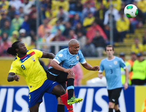 Felipe Caicedo (I), de la selección de Ecuador, observa como cabecea el volante Egidio Arévalo Ríos, de Uruguay, durante partido de las eliminatorias sudamericanas al Mundial-2014, en Quito, el 11 de octubre de 2013. (AFP | Rodrigo Buendia)