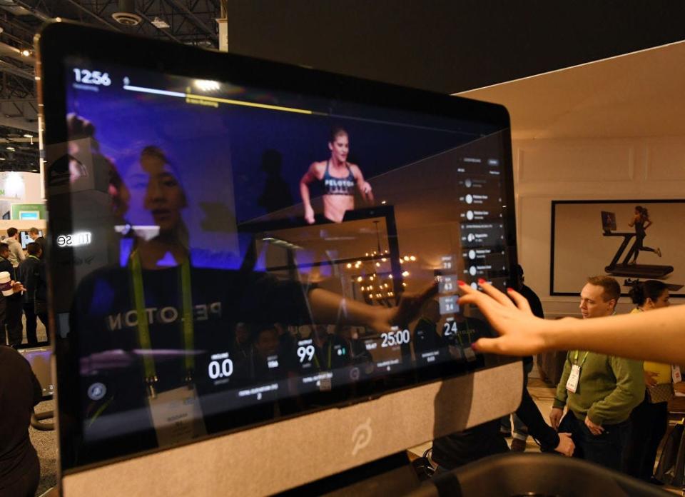 LAS VEGAS, NV - JANUARY 11:  Maggie Lu is reflected in a touch screen as she demonstrates how to select a class on a Peloton Tread treadmill during CES 2018 at the Las Vegas Convention Center on January 11, 2018 in Las Vegas, Nevada. The USD 3,995 workout machine is expected to be available later this year and features a 32-inch touch screen that connects users to instructors giving live or on-demand fitness classes. CES, the world's largest annual consumer technology trade show, runs through January 12 and features about 3,900 exhibitors showing off their latest products and services to more than 170,000 attendees.  (Photo by Ethan Miller/Getty Images)