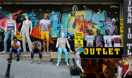 Men sit outside a discount clothing retail store in Istanbul, Turkey, July 13, 2016. REUTERS/Murad Sezer/File Photo