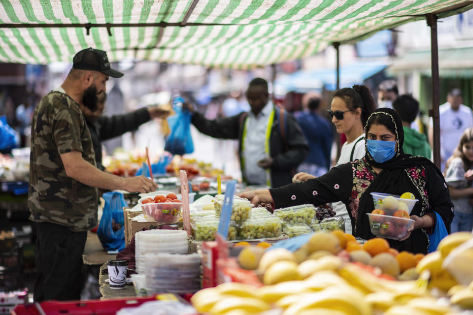 LONDON, UNITED KINGDOM - MAY 26: A member of the public shops for fruit and vegetables at Walthamstow Street Market on May 26, 2020 in London, England. The British government continues to ease the coronavirus lockdown by announcing schools will open to reception year pupils plus years one and six from June 1st. Open-air markets and car showrooms can also open from the same date.  (Photo by Justin Setterfield/Getty Images)