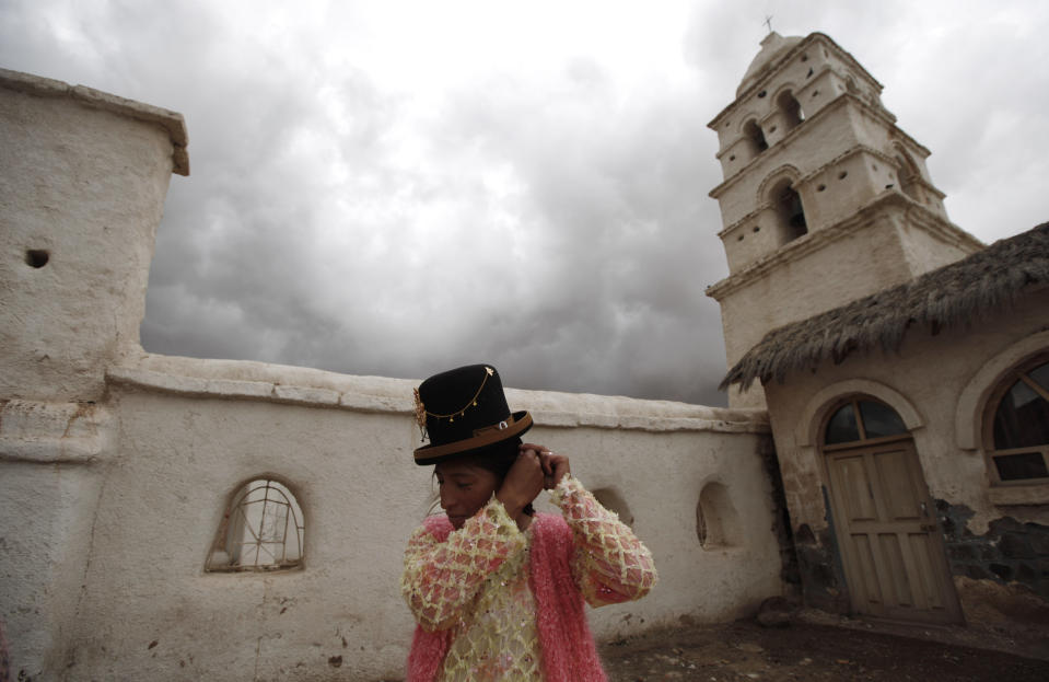 An Aymara woman waits for the newlyweds outside the Sistine Chapel of Los Andes in Curahuara de Carangas, Oruro department, 260 km. (160 miles) south from La Paz, Bolivia, Saturday, Dec. 8, 2012. Built in 1608 to evangelize indigenous Bolivians into the Roman Catholic faith, the chapel these days attracts both the faithful and tourists. (AP Photo/Juan Karita)