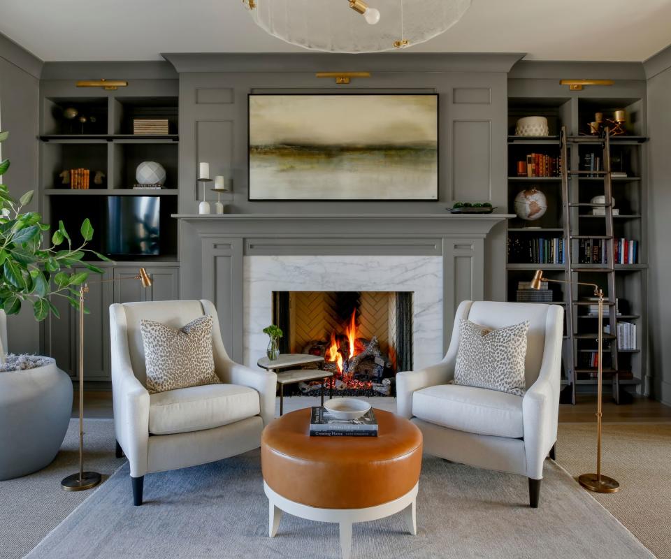 Grey walls, white armchair, orange footstool