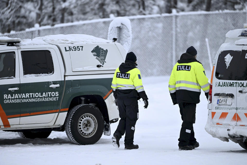 Customs officials walk between Finnish Border Guard vehicles at the Raja-Jooseppi international border crossing station with Russia, in Inari, northern Finland, on Tuesday, Nov. 28, 2023. Finland will close its last remaining road border with Russia due to concerns over migration, Prime Minister Petteri Orpo said Tuesday, accusing Moscow of undermining Finland's national security. Finland already closed seven of its eight of the checkpoints along its long border Russia this month following a surge in arrivals of migrants from the Middle East and Africa. The government accuses Moscow of ushering the migrants toward the Finnish border. (Emmi Korhonen/Lehtikuva via AP)