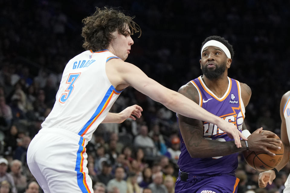 Phoenix Suns forward Royce O'Neale, right, gets fouled by Oklahoma City Thunder guard Josh Giddey (3) during the second half of an NBA basketball game, Sunday, March 3, 2024, in Phoenix. (AP Photo/Rick Scuteri)