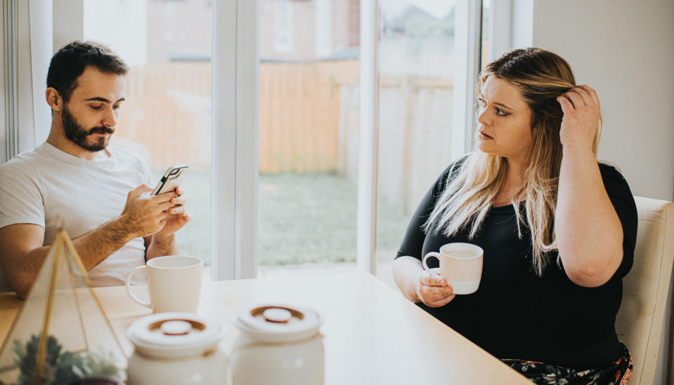 boyfriend on the phone and girlfriend looking upset