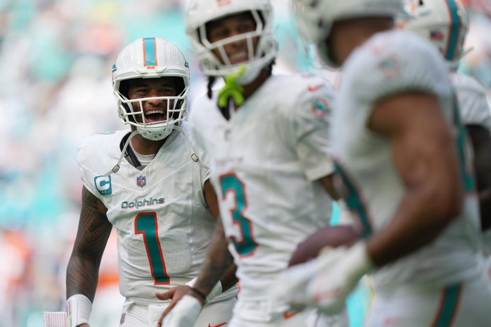 Miami Dolphins quarterback Tua Tagovailoa (1) celebrates a touchdown by Miami Dolphins running back De'Von Achane (28) during the fourth quarter of an NFL game at Hard Rock Stadium in Miami Gardens, Sept. 24, 2023.