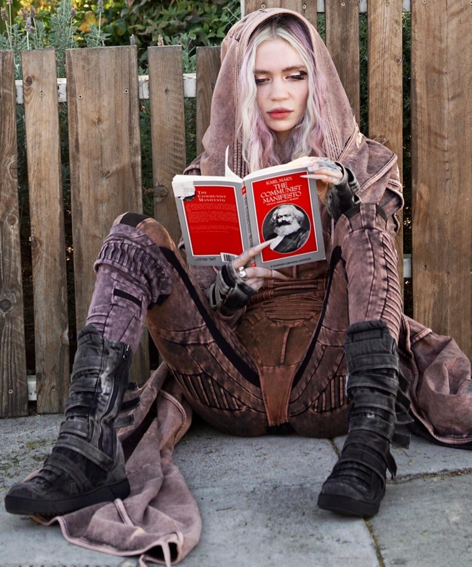 Grimes, Elon Musks Ex was spotted on the street for the first time reading “The communist Manefesto” as she sat on the street by herself.