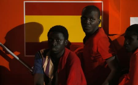 Migrants wait to disembark from a rescue boat at the port of Malaga