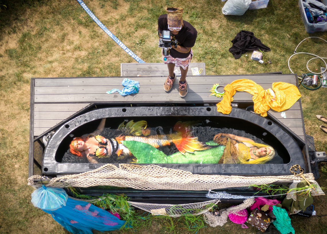 Aurora Rose Watkins as Mermaid Nellie, left, and Nicole Loudon as Mermaid Citrise, right, float in a 3,000 gallon tank as Jor-El Washington operates a camera during the filming of a promotional video.