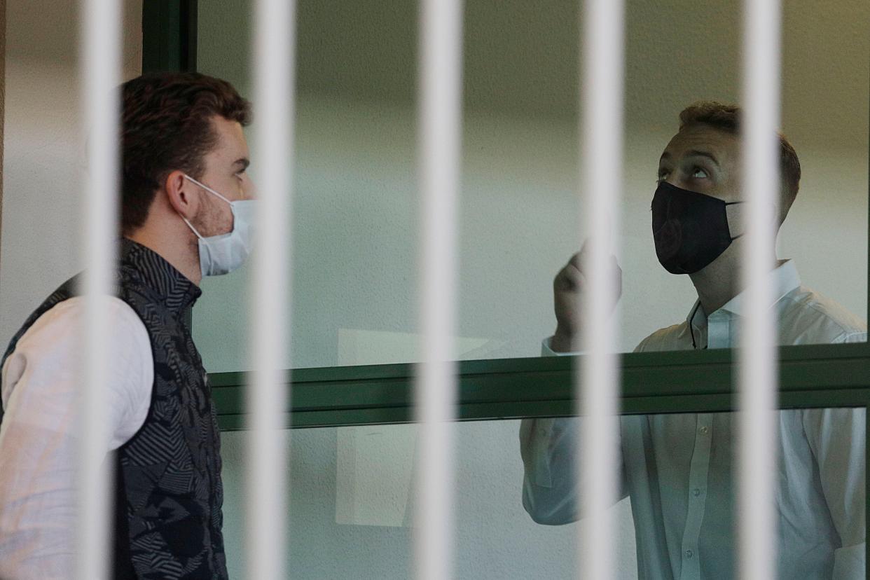 Finnegan Lee Elder, right, points the sky after showing a crucifix to co-defendant Gabriel Natale-Hjorth before a jury began deliberating their fate (AP)