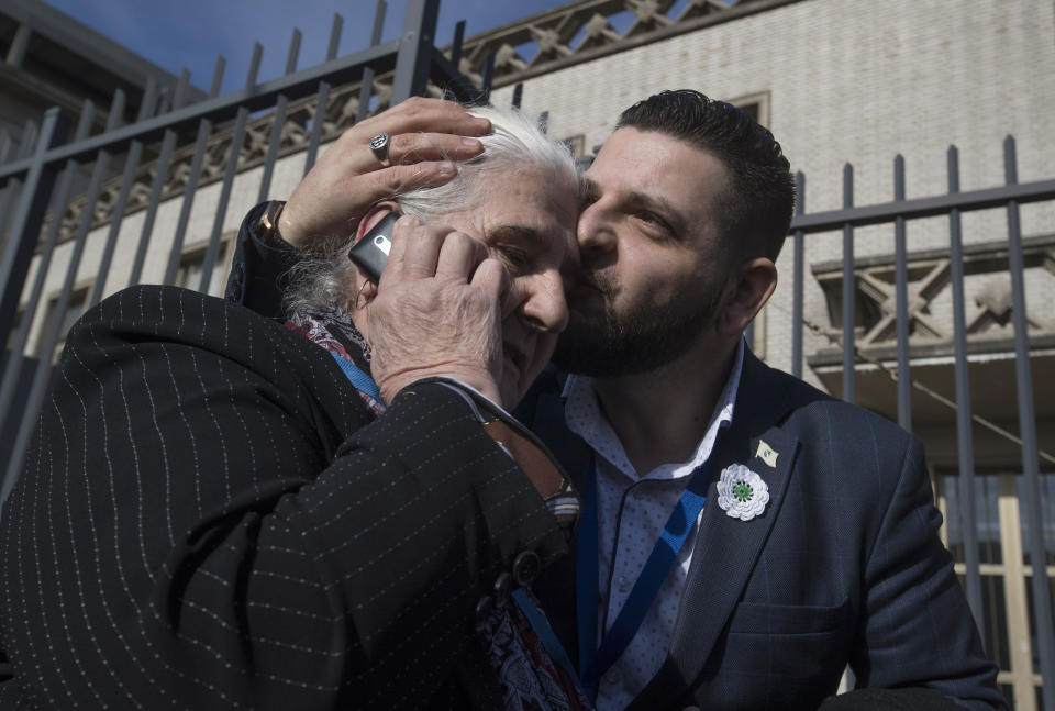 Munira Subasic of the Mothers of Srebrenica, left, is hugged after the court upheld the convictions of former Bosnian Serb leader Radovan Karadzic at International Residual Mechanism for Criminal Tribunals in The Hague, Netherlands, Wednesday, March 20, 2019. Nearly a quarter of a century since Bosnia's devastating war ended, Karadzic heard the final judgment upholding 2016 convictions for genocide, crimes against humanity and war crimes, and increased his 40-year sentence to life. (AP Photo/Peter Dejongl)