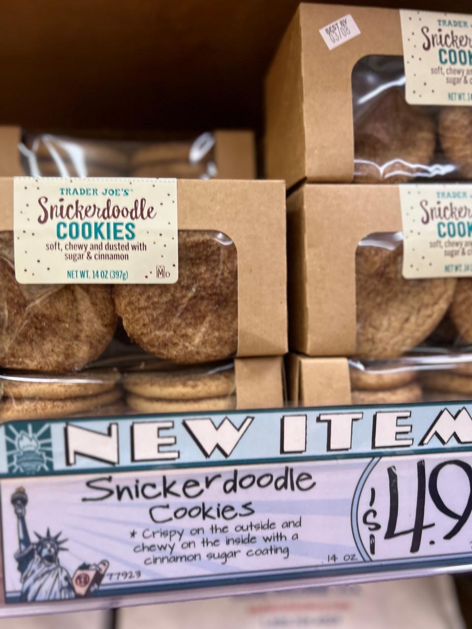 Shelves stocked with Trader Joe's Snickerdoodle Cookies, labeled as a new item, with a price tag of $4.99