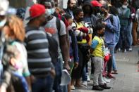 Migrants from Haiti and Central America line up to regularize their migratory situation outside of the Mexican Commission for Aid to Refugees (COMAR), in Mexico City