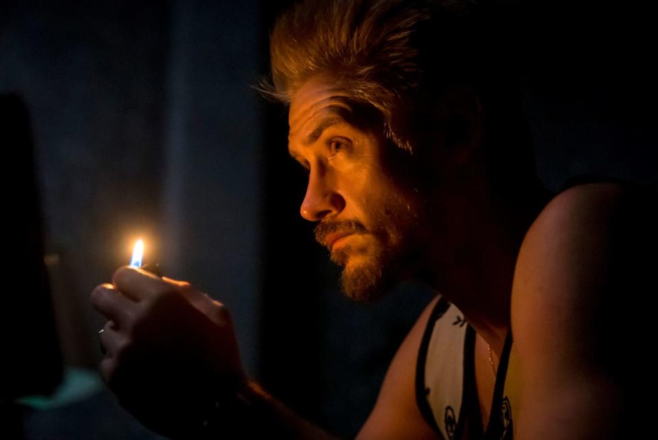 A still from 'Justified: City Primeval' of Boyd Holbrook holding a match near his face in the dark 