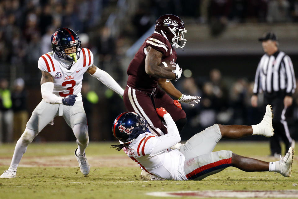 Nov 23, 2023; Starkville, Mississippi, USA; Mississippi State Bulldogs running back Jo’Quavious Marks (7) runs the ball as Mississippi Rebels defensive back Daijahn Anthony (3) and linebacker Jeremiah Jean-Baptiste (11) make the tackle during the second half at Davis Wade Stadium at Scott Field. Mandatory Credit: Petre Thomas-USA TODAY Sports