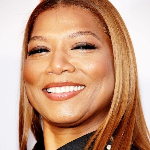 Queen Latifah smiling at an event wearing a sequined blazer