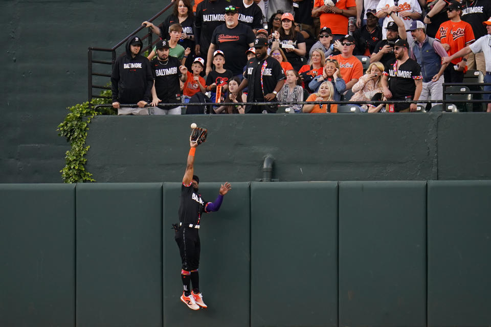 Baltimore Orioles center fielder Cedric Mullins goes up to make a catch near the wall on a ball hit by Texas Rangers' Josh Jung during the second inning of a baseball game, Friday, May 26, 2023, in Baltimore. (AP Photo/Julio Cortez)