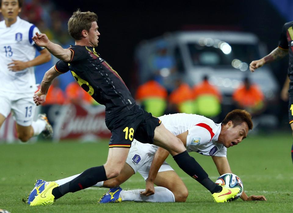 Belgium's Nicolas Lombaerts fights for the ball with South Korea's Kim Shin-wook (R) during their 2014 World Cup Group H soccer match at the Corinthians arena in Sao Paulo June 26, 2014. REUTERS/Eddie Keogh